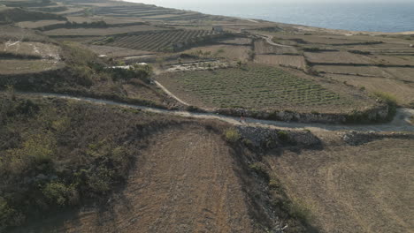 Aerial-Footage-of-a-runner,-male-jogging-in-malta