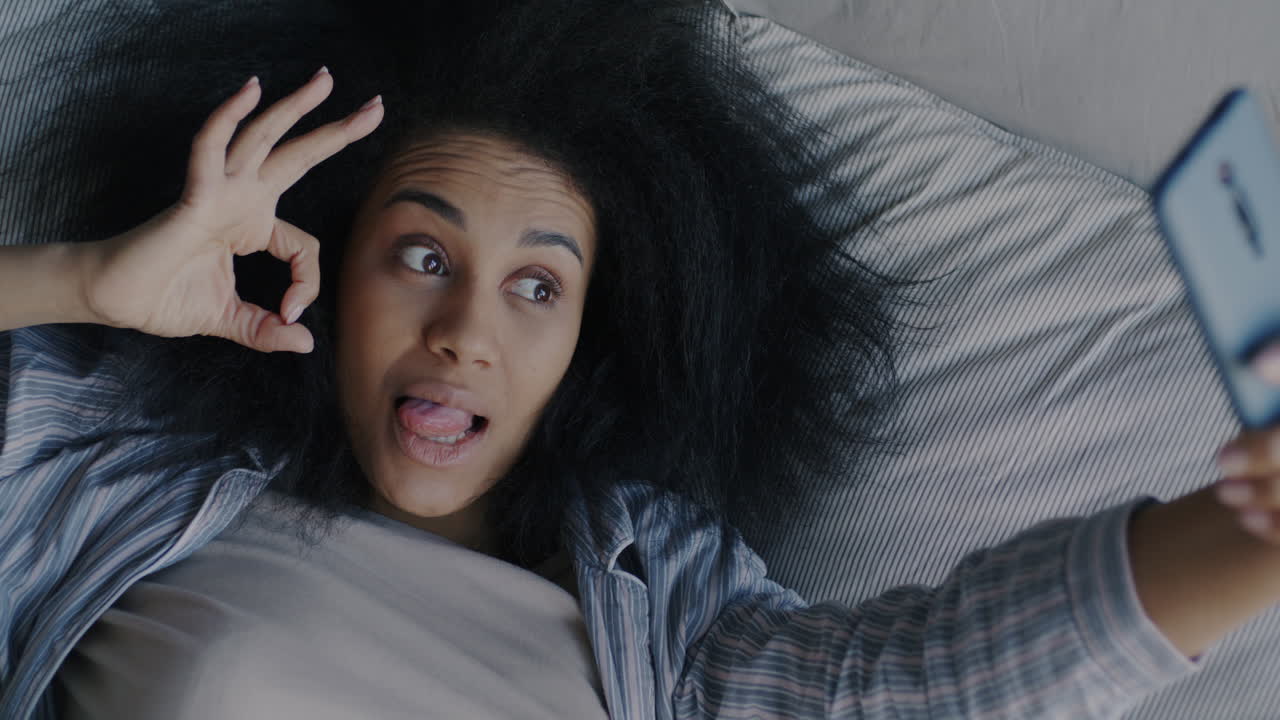 mujer tomando selfies en la cama