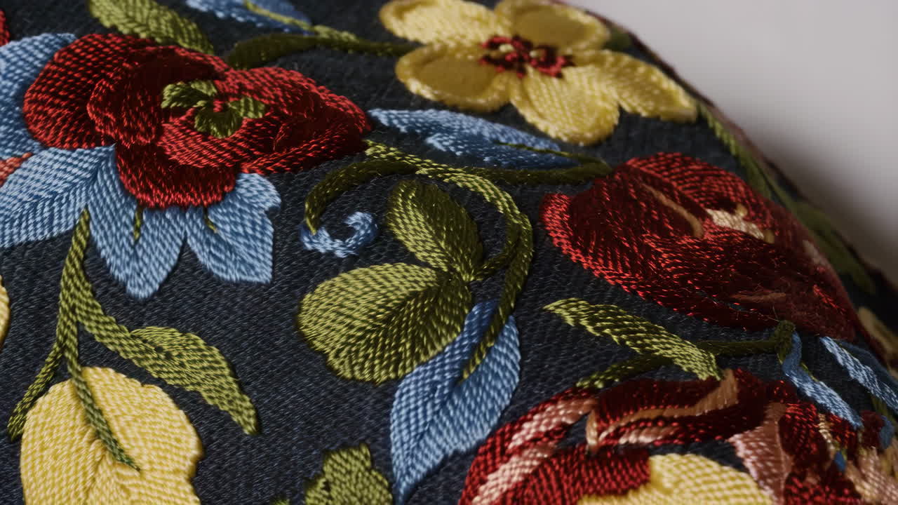 Close-up of vibrant floral embroidery on dark fabric