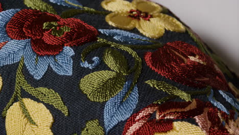 close-up of vibrant floral embroidery on dark fabric