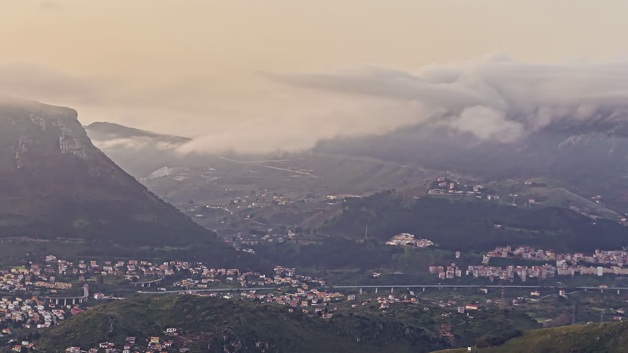 nubes debajo de los picos sobre el valle de la ciudad de palermo, sicilia al amanecer - lapso de tiempo