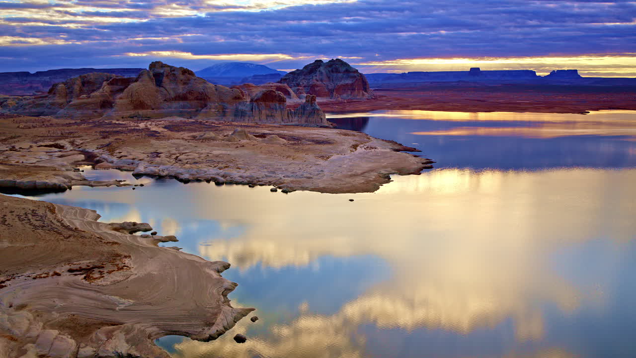 A dynamic aerial shot displaying the endless desert beauty and dramatic red rocks near Lake Powell.