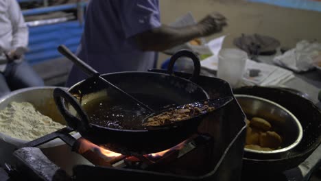 taking the fresh fried street food from the basket ready to give to a client