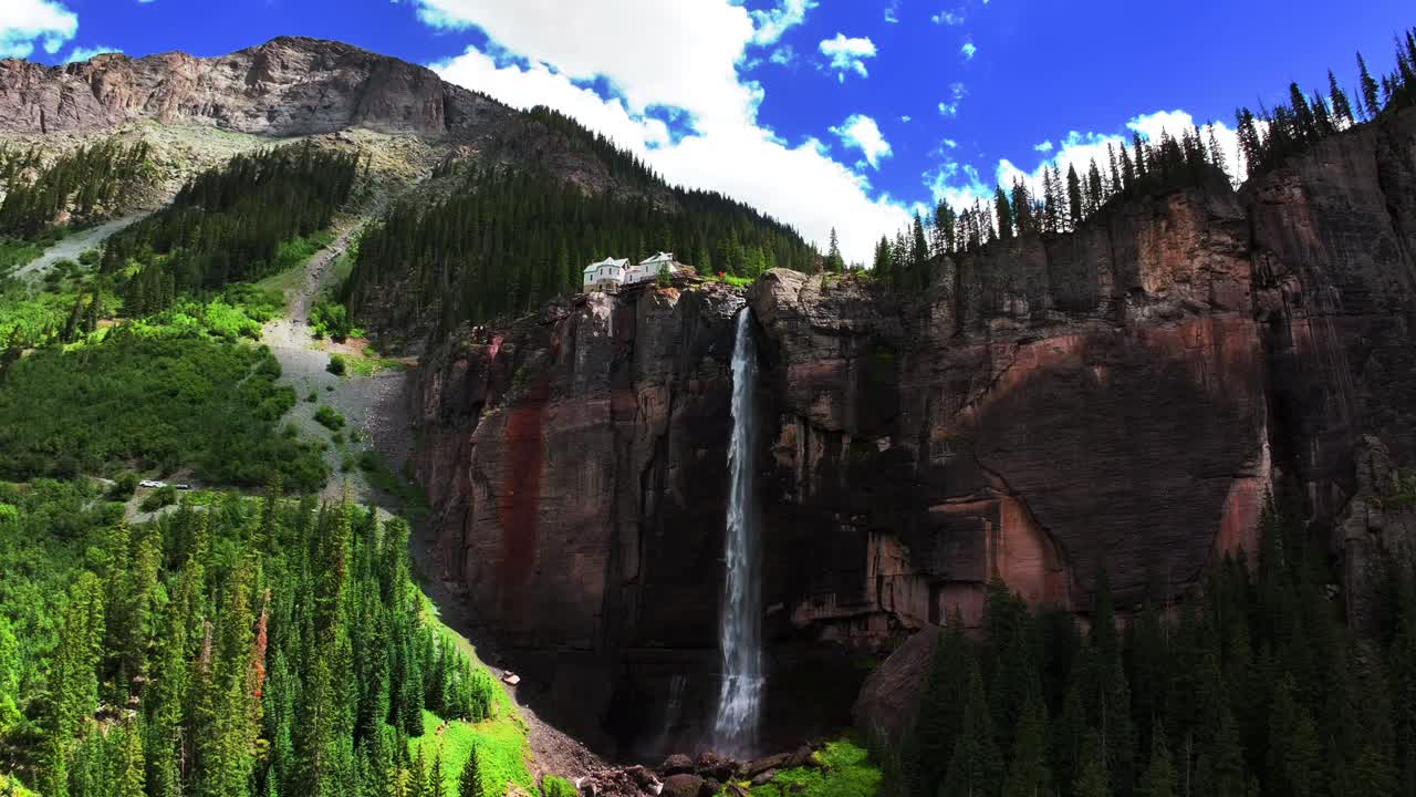 Telluride Bridal Veil Falls Waterfall Colorado powerplant house aerial drone circle left pan sun summer green Box Canyon Black Bear Pass Road Rocky Mountains 4wd blue sky cliffside Uncompahgre Forest