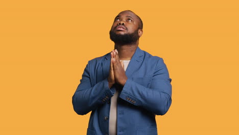 man praying to his god, asking for forgiveness, studio background