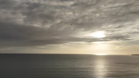 plane in flight. dramatic clouds over ocean. steady tracking drone shot.