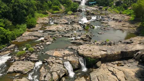 aerial drone shot of munnar’s beautiful waterfall surrounded by mist and forests