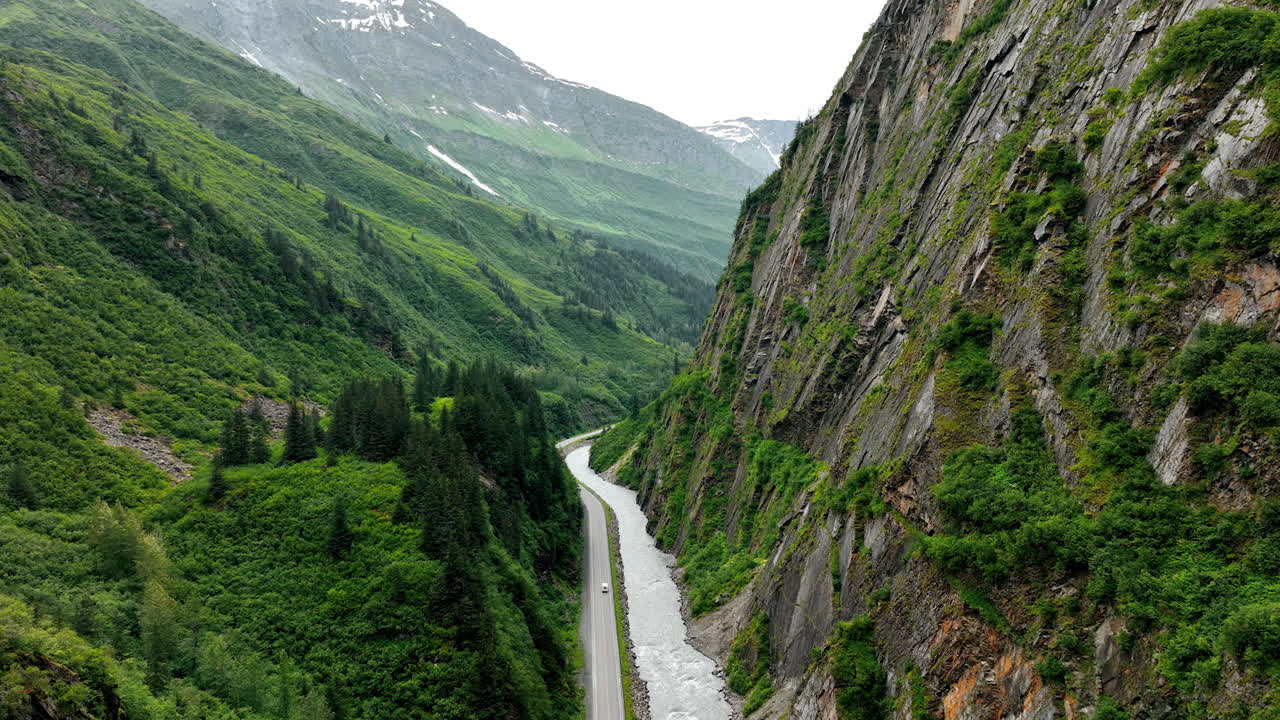 Alaska stunning rugged views. Discover Alaska stunning valley, where mountains meet lush green foliage by a winding river. Nature's beauty awaits!