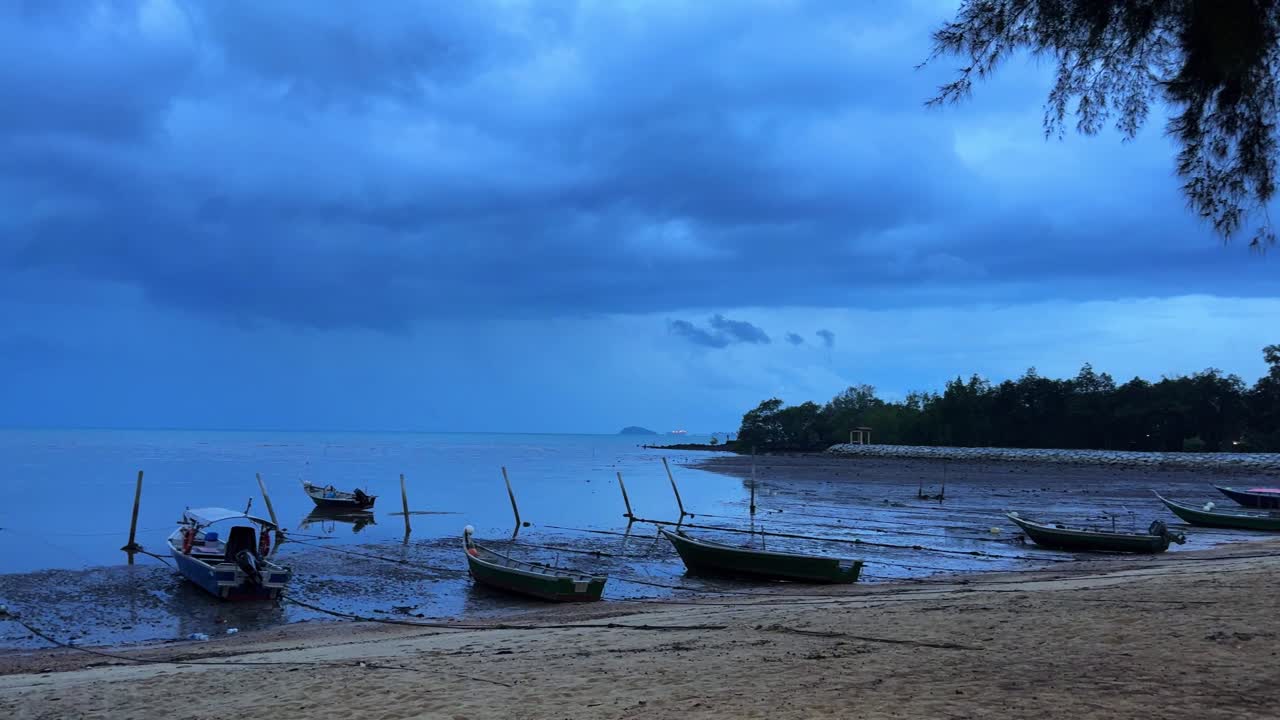 Deserted beach at dusk in Port Dickson Malaysia, abandoned fishing boats