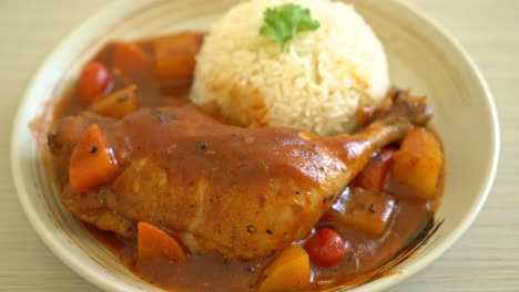 homemade chicken stew with tomatoes, onions, carrot and potatoes on plate with rice