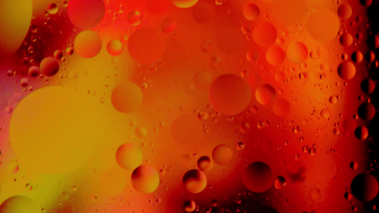 Bolle d'olio che galleggiano nell'acqua su sfondo colorato, primo piano, macro, sfondo, modello