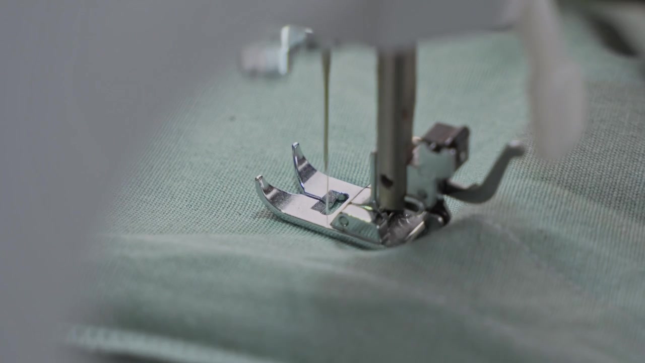 Man Stitching Clothes Using an Electric Sewing Machine