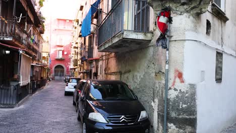 a car navigates a narrow alley in naples