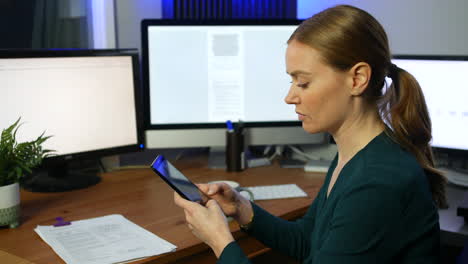 a happy business woman taking a break and drinking coffee while using herphone in an office