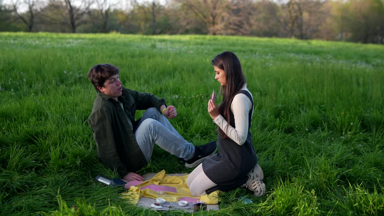 Couple Playing Cards in a Park