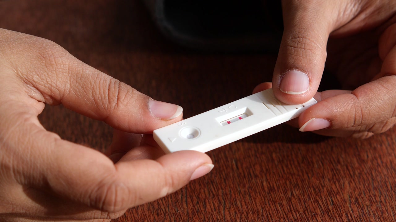 Hands Holding Rapid Diagnostic Test Showing Positive Result