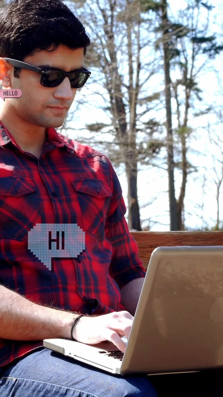 Animation of hi and hello texts in speech bubbles, caucasian man working on laptop in outdoors