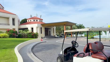 golf cart moving near entrance and fountain