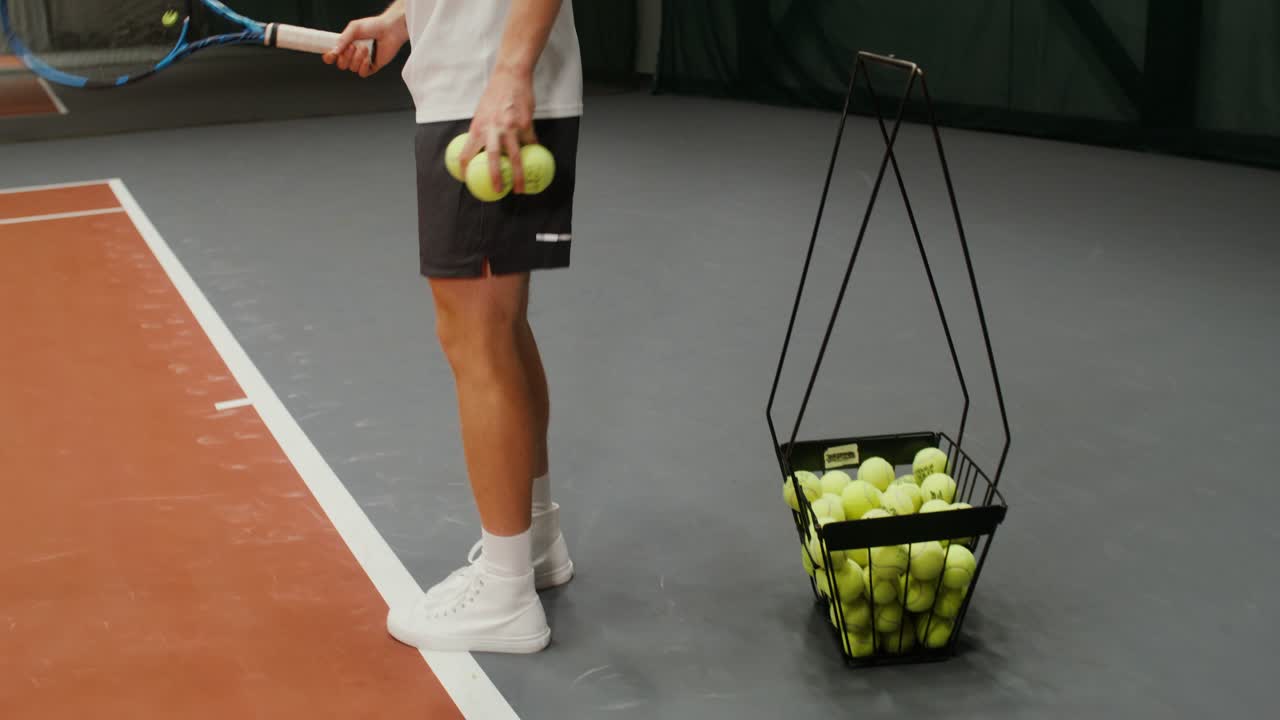 Mann spielt Tennis in der Halle