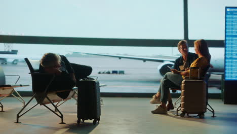 people waiting at the airport terminal with luggage