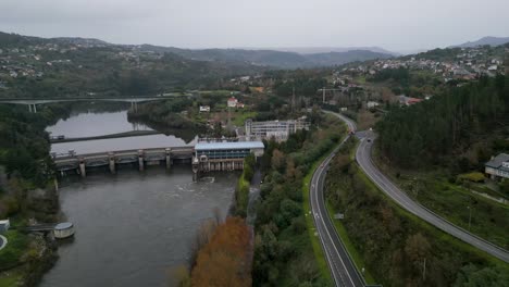 paso aéreo por encima de la carretera que bordea el río por la presa de agua y la central eléctrica de velle en ourense, galicia, españa