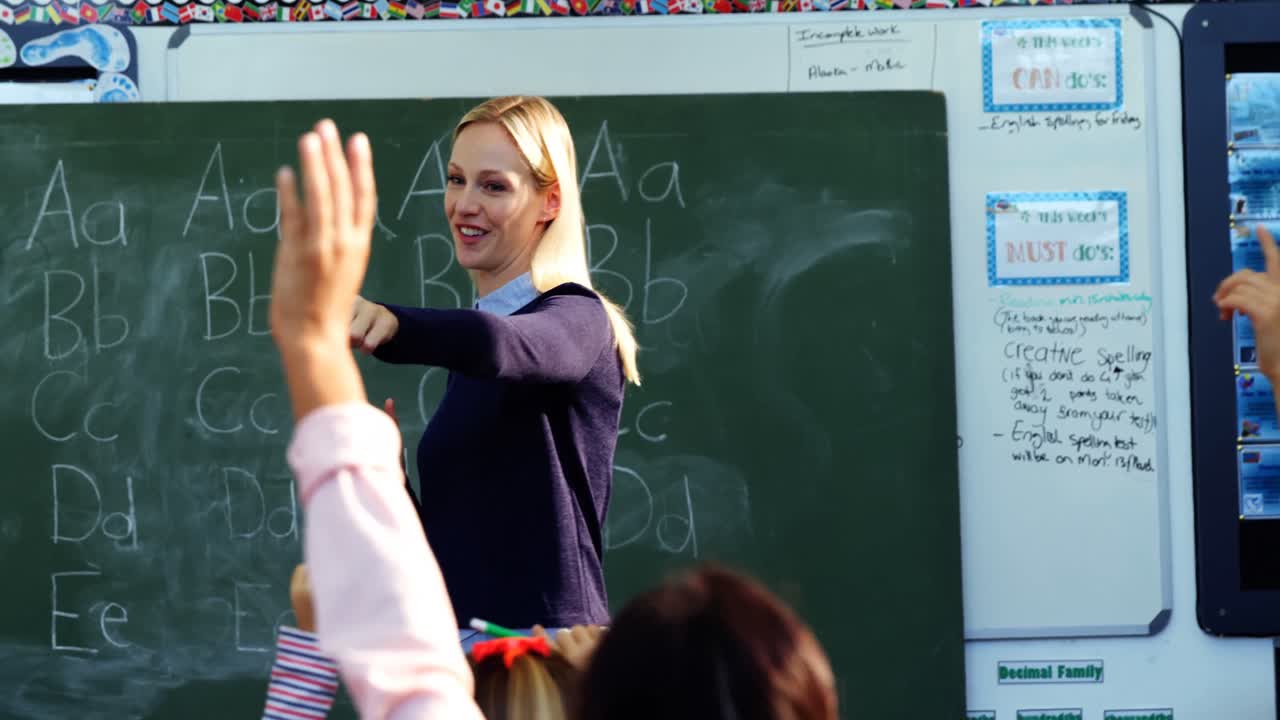 maestra haciendo preguntas a sus estudiantes en el salón de clases