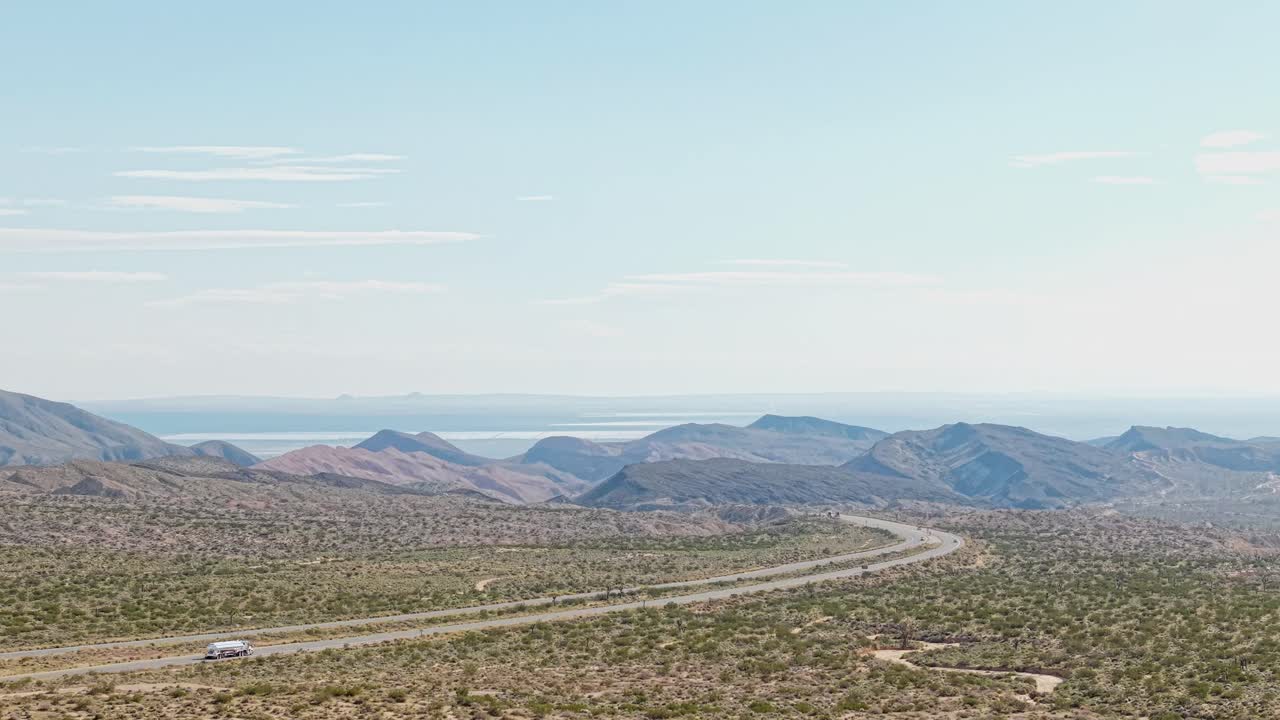 The drone captures vast open spaces framed by towering red cliffs, offering a detailed look at the canyon’s rich geology and desert terrain