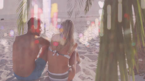 on sandy beach, couple sitting with colorful light reflections over them
