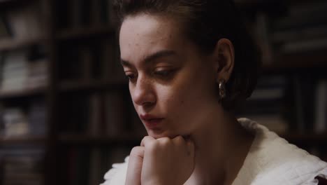 woman in thoughtful pose in a library