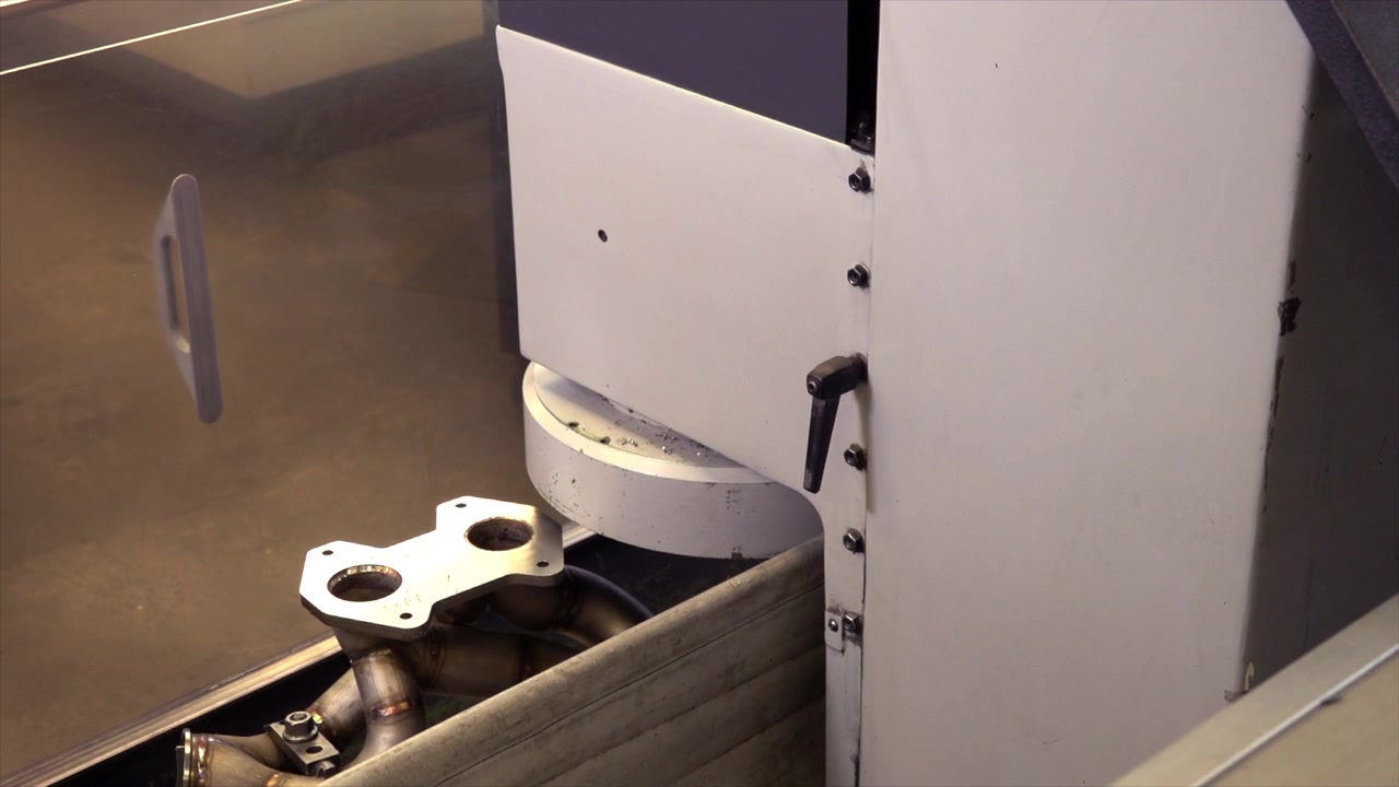 A moving wide shot of engine block machining revealing shiny steel as it does it's work.