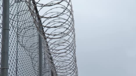 prison razor wire fence in snow in slow motion