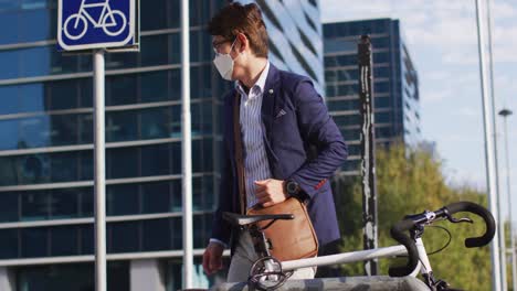 Asian-man-wearing-face-mask-locking-his-bicycle-at-corporate-park