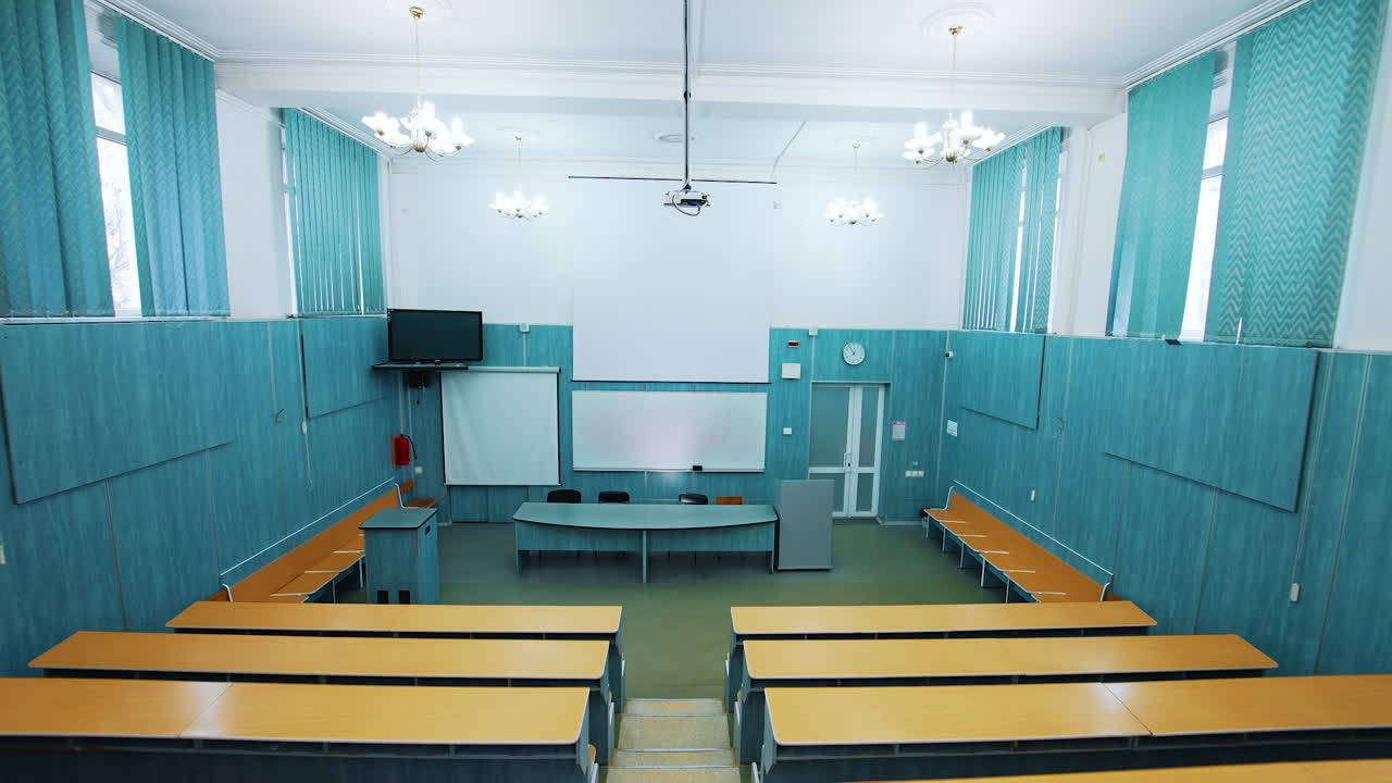 Empty lecture hall in the university. Beautiful classroom in the educational centre with modern interior. Conference hall with blackboard and modern equipment. Panoramic view.