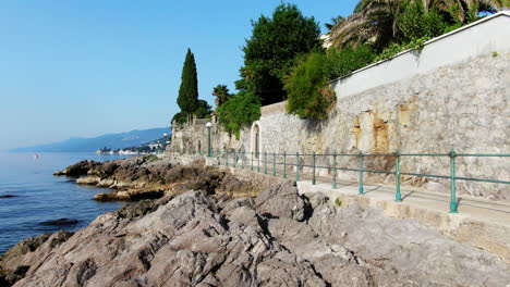 rocky coast of town volosko with big cruiser anchored at sea, aerial