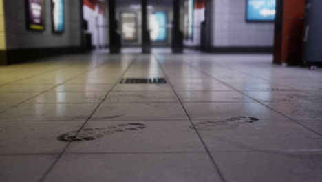 footprints on the tiled floor of a subway station in a busy urban area