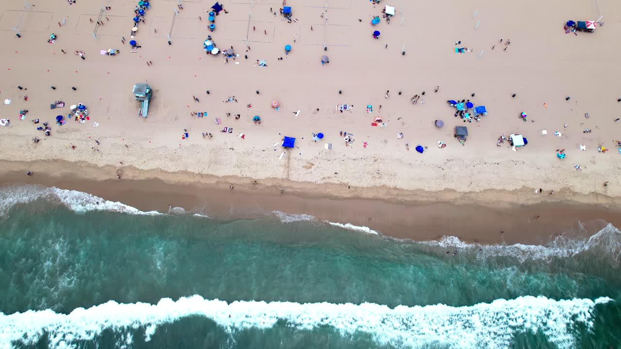 Tropical sandy Manhattan beach with ocean waves hitting coastline, aerial birds-eye