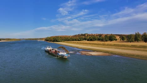 fotografía aérea de un dragador descargando arena dragada en un gran río, un día soleado