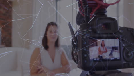 animación de la red de conexiones a través de la pantalla de la cámara con una vlogger femenina grabando vlog en casa