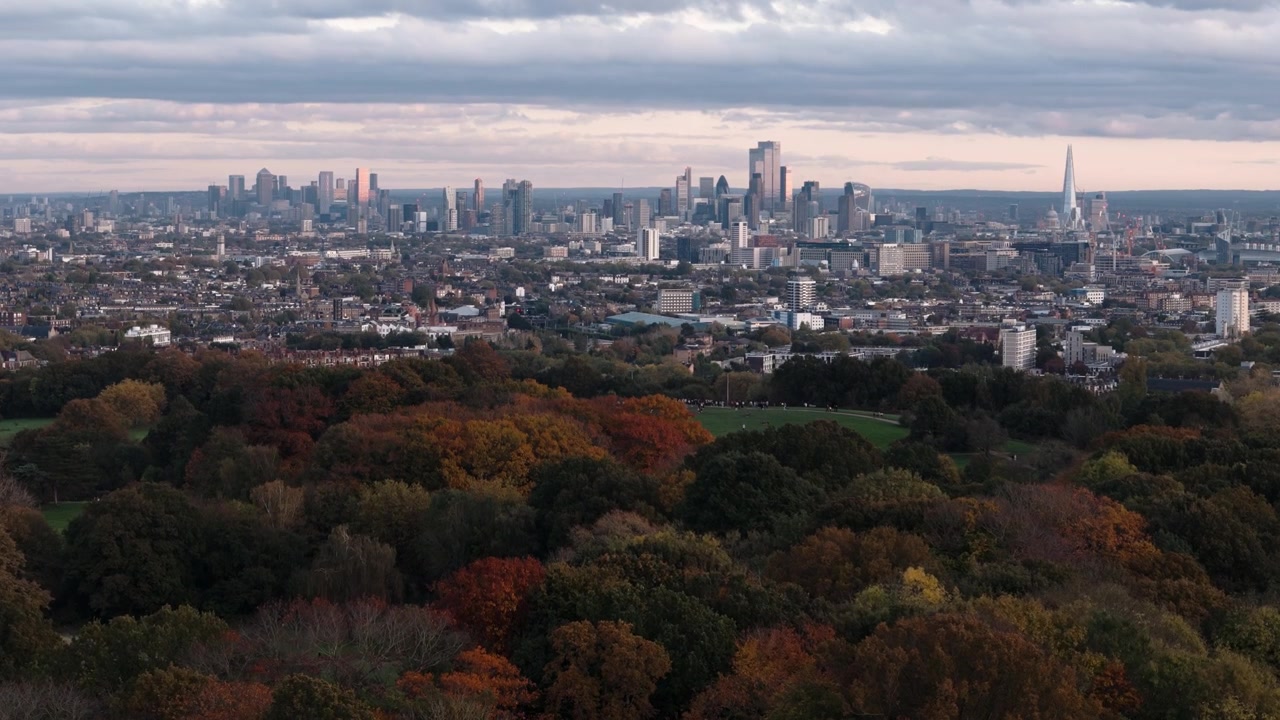 Avvicinamento da lontano a Parliament Hill con alberi colorati e lo skyline di Londra