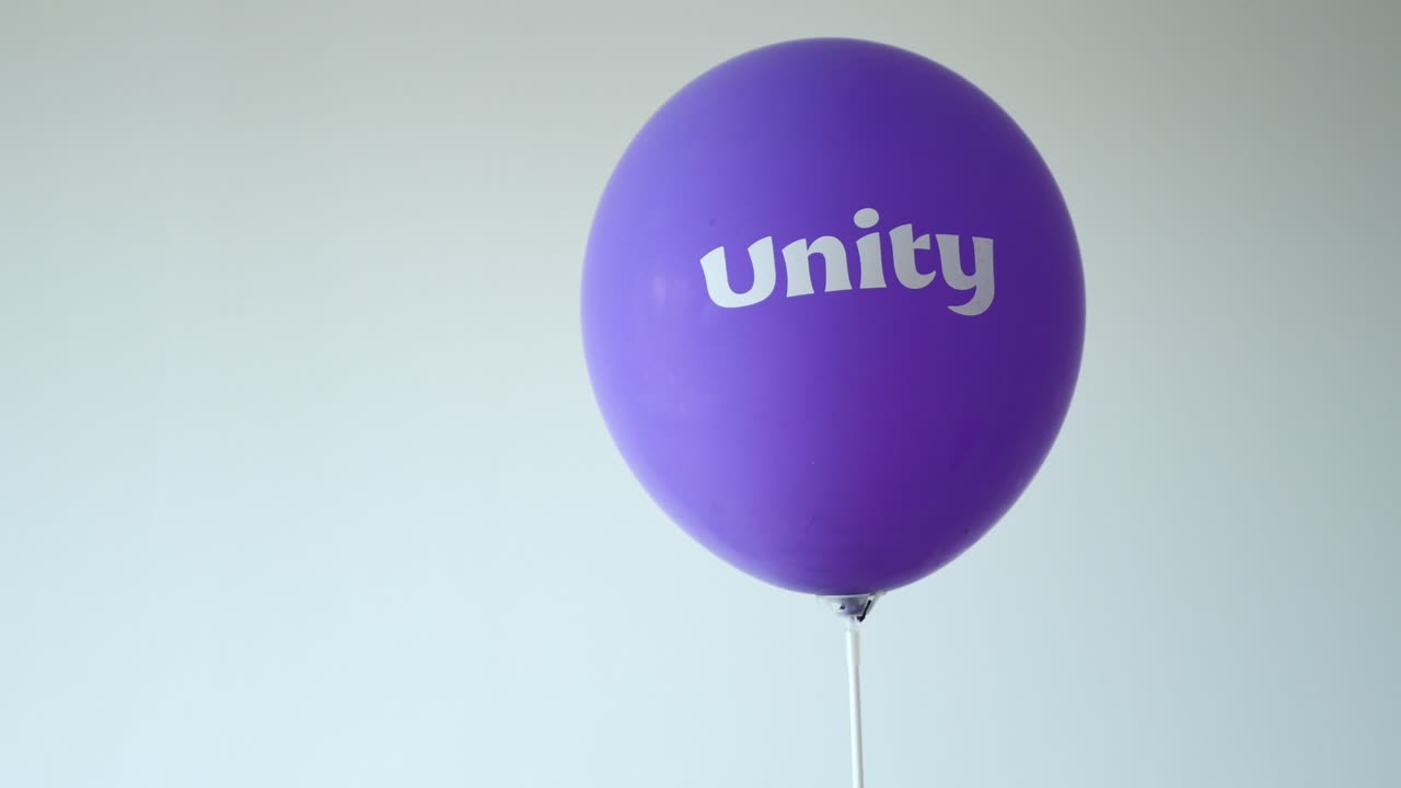 보라색 풍선에 있는 유니티 텍스트