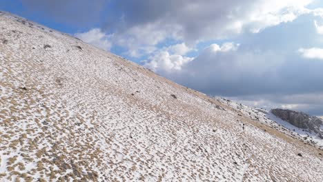 Hikers-ascend-along-steep-trail-to-summit-peak-in-Peloponnese-mountains-on-sunny-day