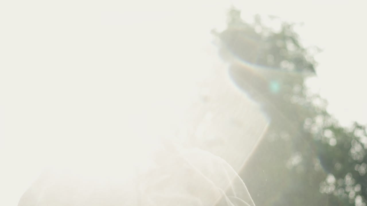 햇빛 속으로 손을 뻗는 흰색 남성, 팔을 올리고 역광이 비치는 숲속 풍경(렌즈 플레어 및 과다 노출된 빛 포함), 하이커 스트레칭, 요가 자세, 공원 운동, 구도자 의식, 따뜻한 안개와 희망찬 영화적 에너지