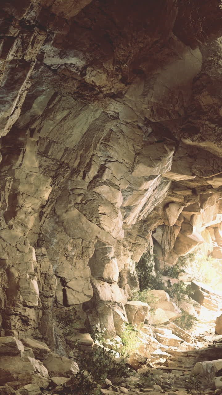 Esplorando una grotta rocciosa con la luce del sole che filtra sullo sfondo.