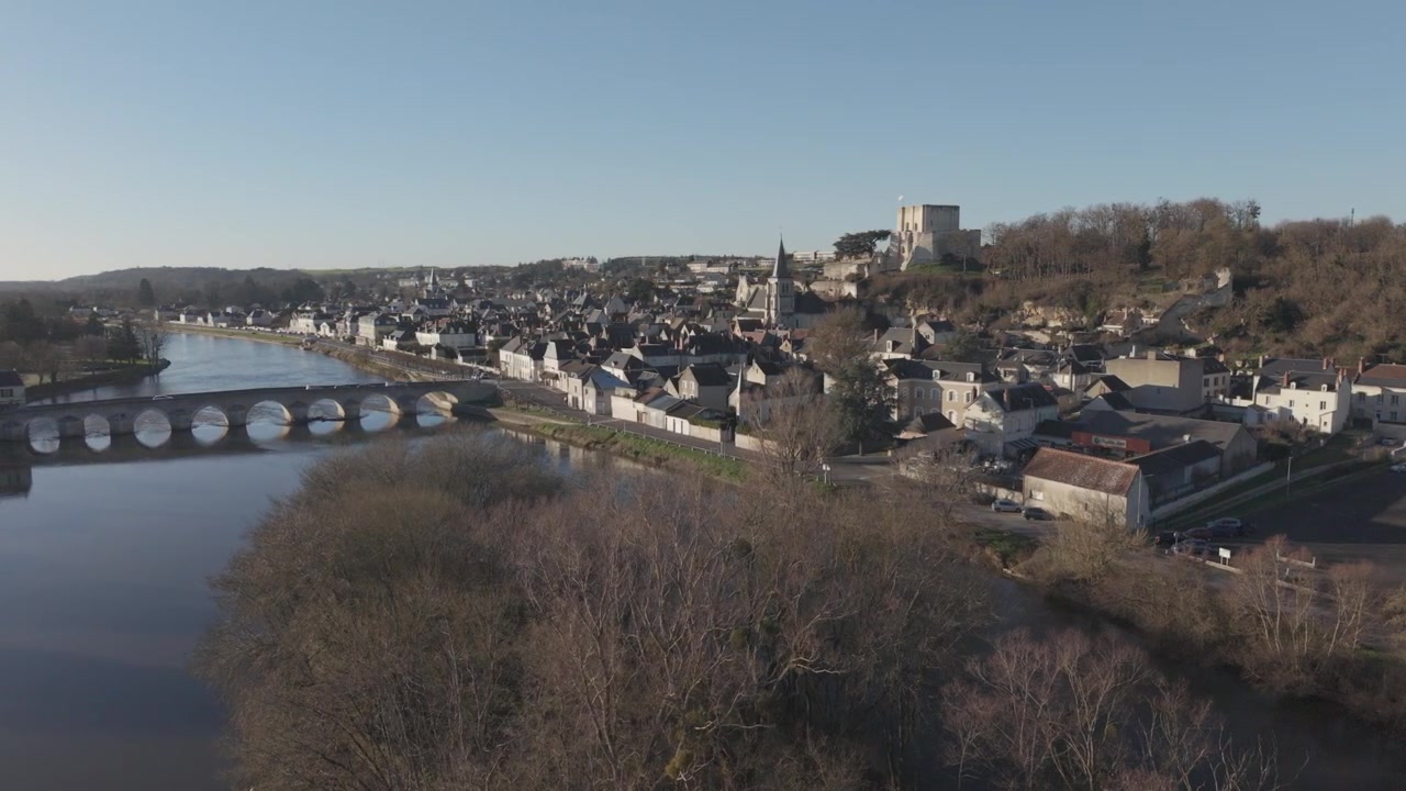 Una vista aérea muestra un puente de arco de piedra cruzando el río Loira hacia un pueblo francés histórico con una aguja de iglesia