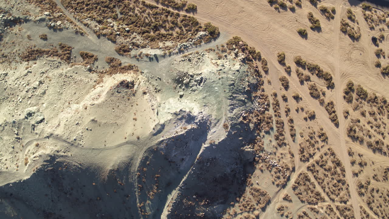 캘리포니아 사막의 위 아래 공중 드론 녹색  ⁇  언덕에 바위와 4x4 트레일