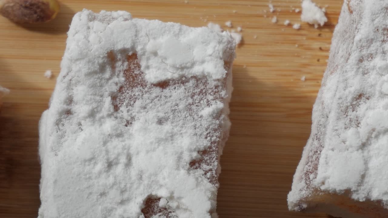 Sweet Cyprus delight dusted with powdered sugar on a wooden surface, traditional treat