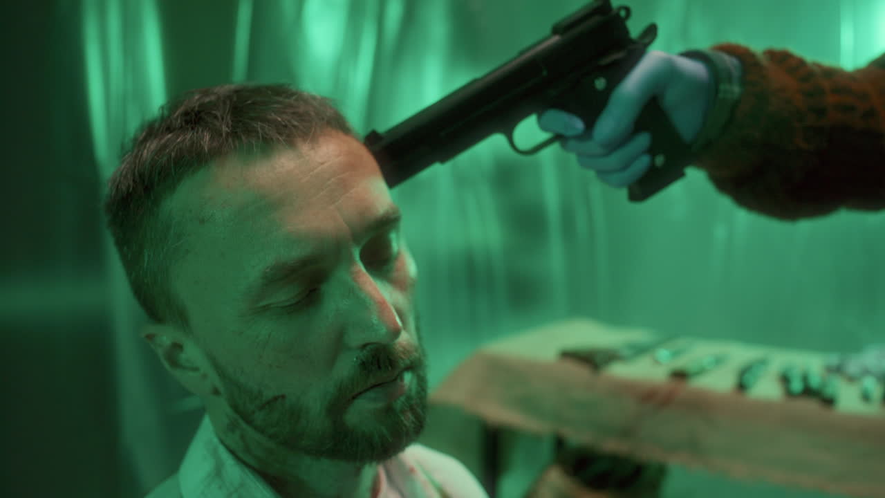 un rehén agotado hablando con un criminal con una pistola en la cabeza.