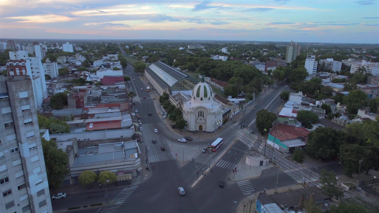 Vista aérea 4K con dron de la estación de tren de La Plata en Buenos Aires, Argentina. Hito histórico del transporte rodeado por el paisaje urbano de la ciudad y su distintivo patrimonio arquitectónico.