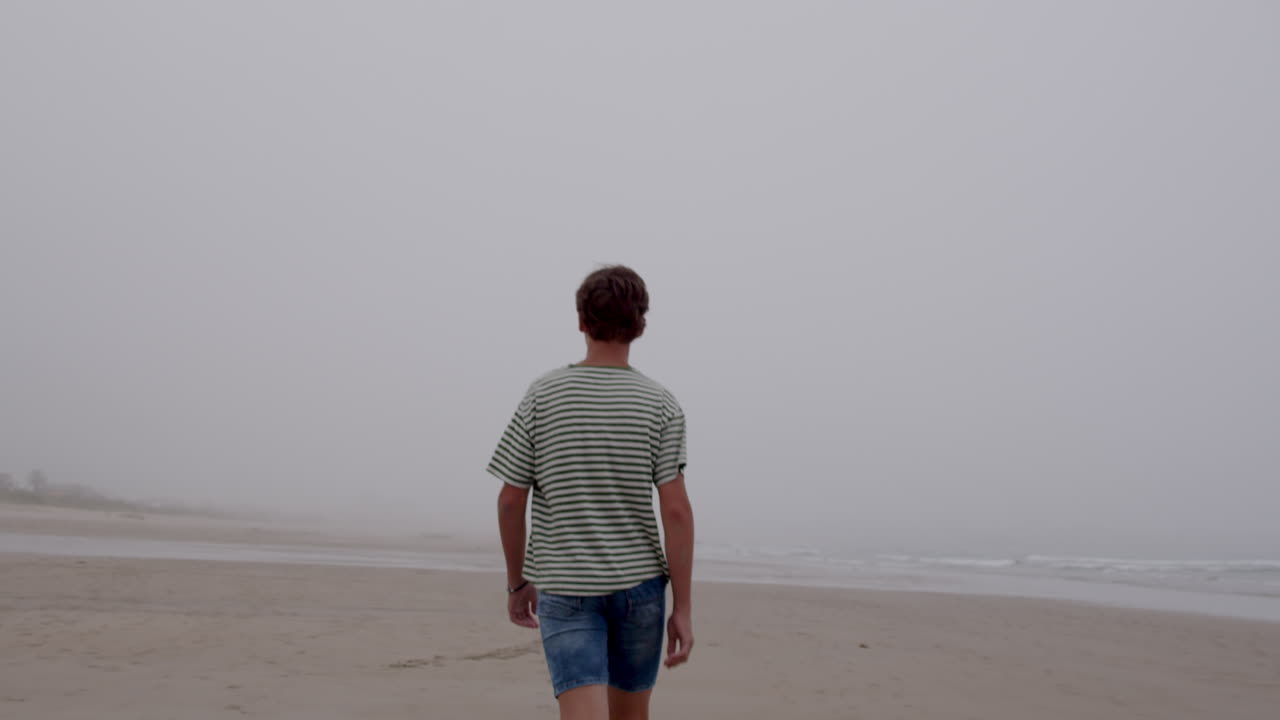 Teenager går på en tåget strand