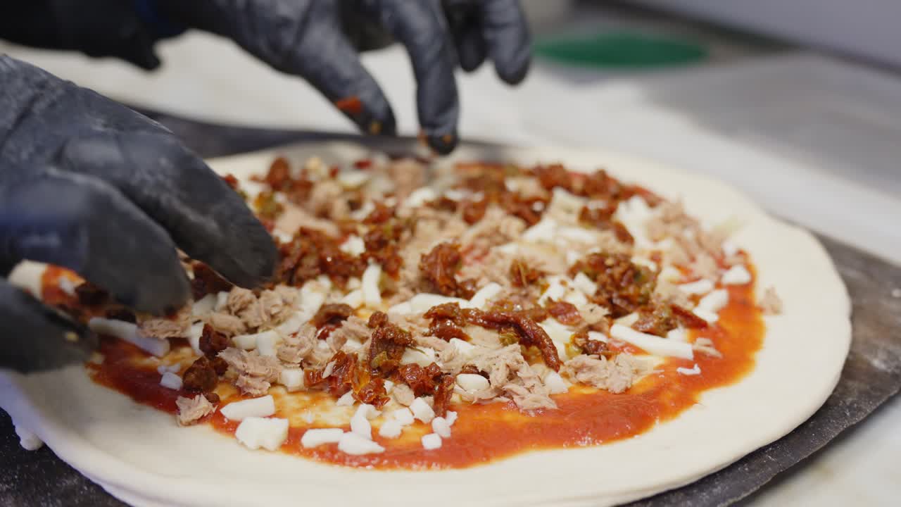 레스토랑 주방에서 피자를 만드는 주방장이 보기를 닫습니다.